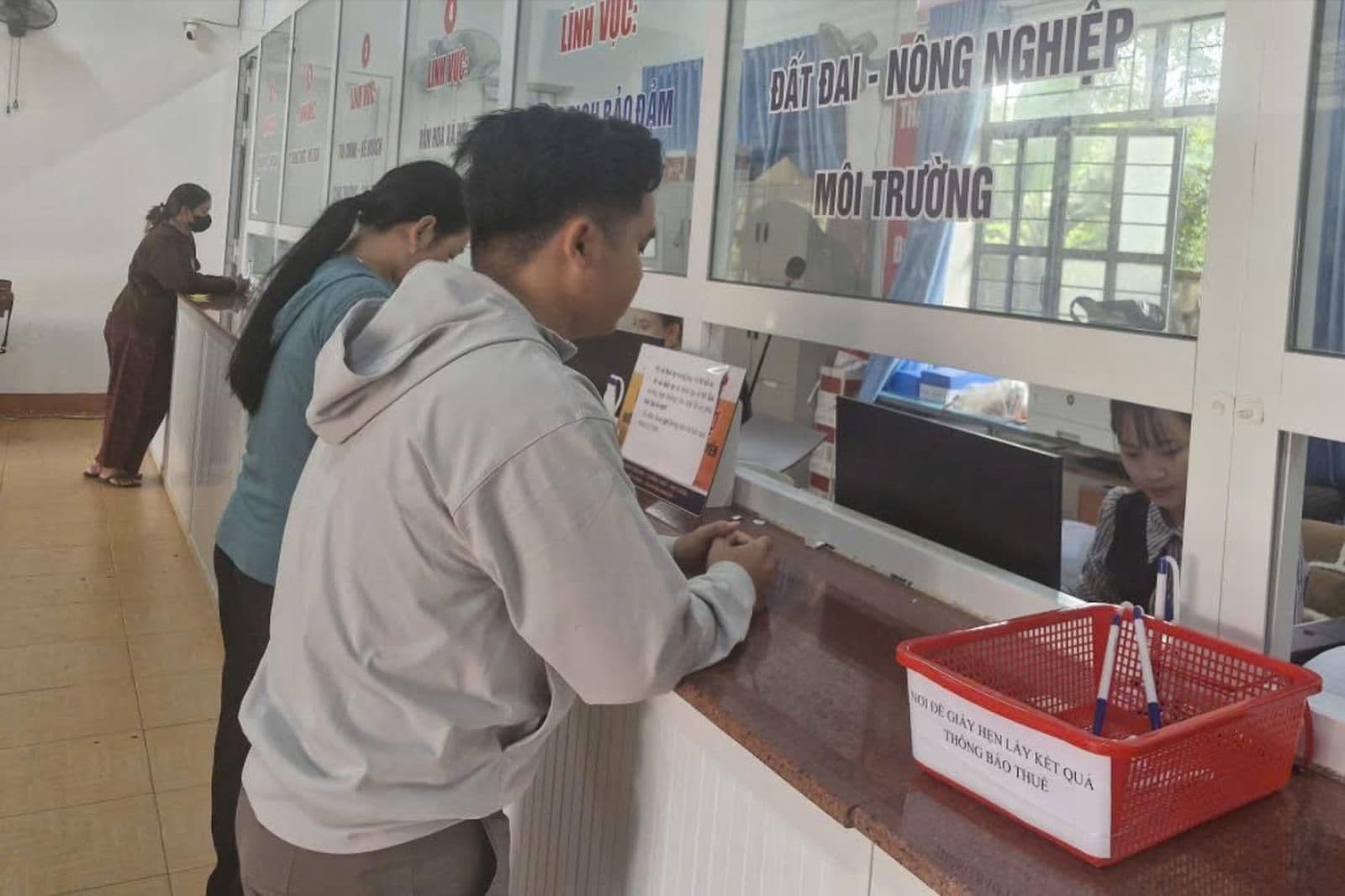 Người dân giao dịch tại quầy hành chính công cấp xã, thể hiện sự tương tác giữa chính quyền và người dân.