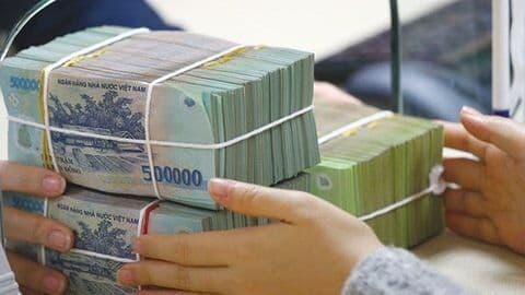 Người dân giao dịch tiền mặt tại ngân hàng, minh họa cho hoạt động gửi tiền và huy động vốn