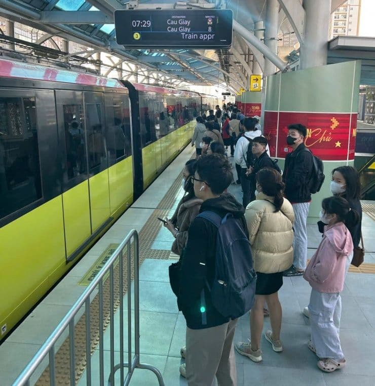Người dân Hà Nội chờ tàu điện đô thị, thể hiện sự thay đổi thói quen đi lại do giá xăng tăng.