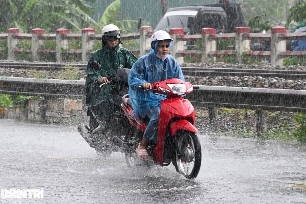 Người dân Hà Nội chật vật di chuyển qua đoạn đường ngập nước do mưa lớn.
