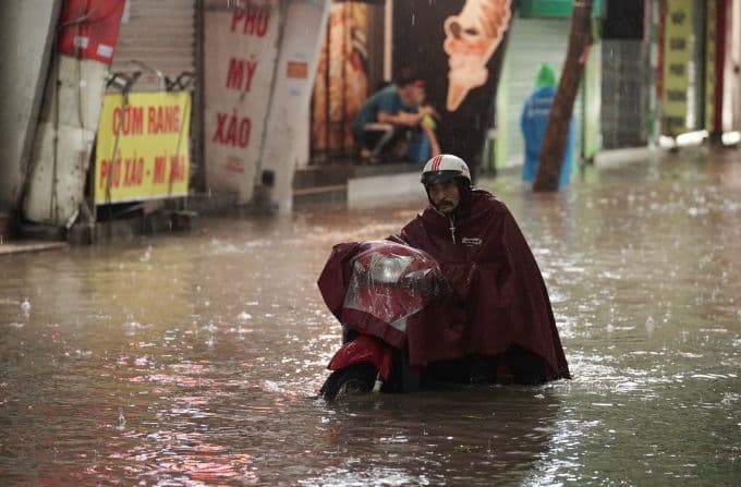 Người dân Hà Nội di chuyển khó khăn trên phố ngập nước do mưa lớn bất ngờ