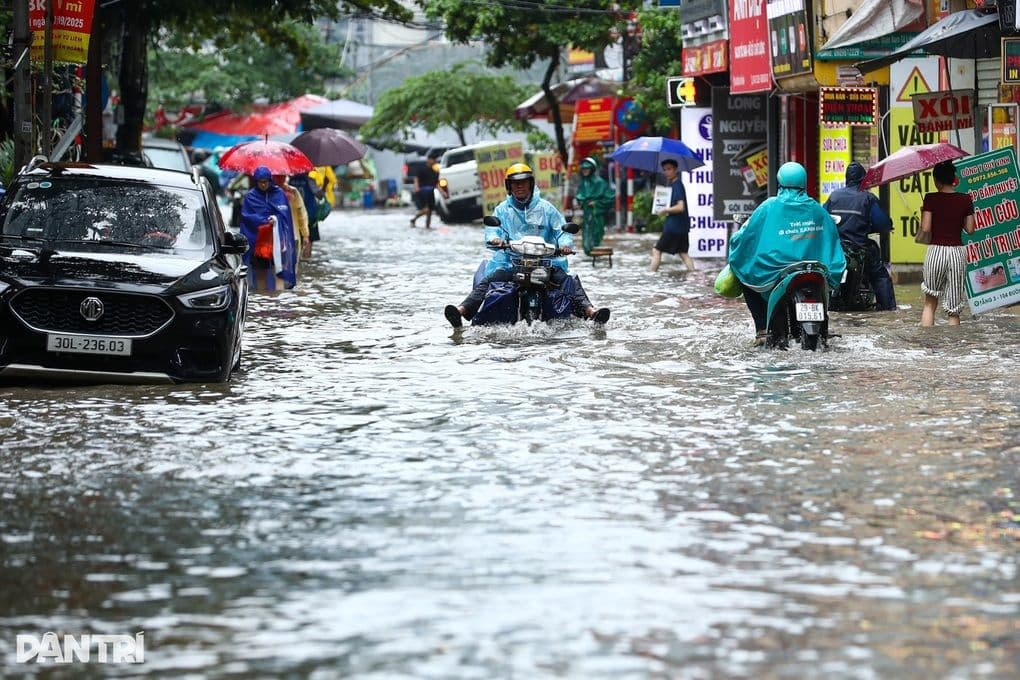 Người dân Hà Nội di chuyển qua đường phố ngập lụt do mưa lớn
