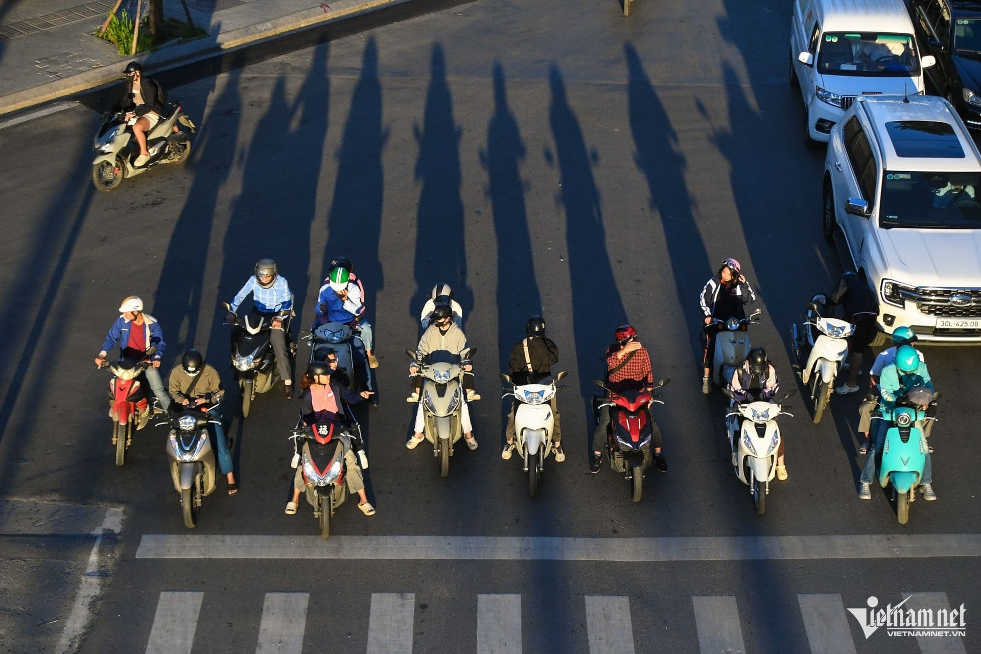 Người dân Hà Nội di chuyển trên đường phố vào buổi sáng sớm hoặc chiều tà với nắng hanh và gió se lạnh, thể hiện nhịp sống đặc trưng của mùa thu đông.