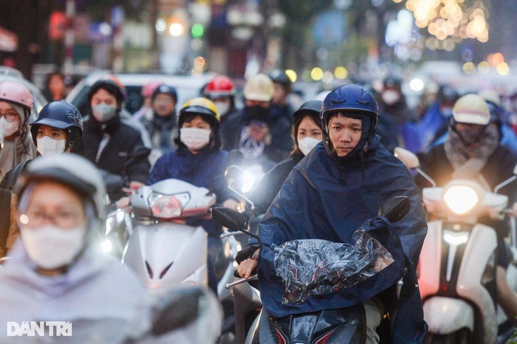 Người dân Hà Nội di chuyển trên đường trong không khí lạnh và mưa, phản ánh tác động của dự báo thời tiết đến đời sống hàng ngày.