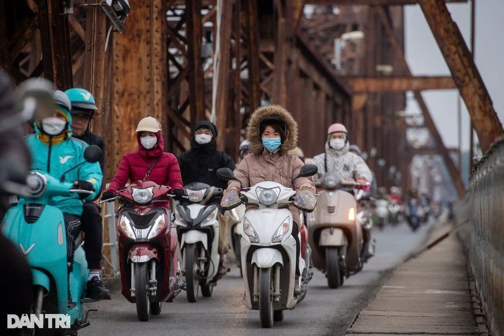 Người dân Hà Nội mặc áo ấm, đeo khẩu trang di chuyển qua cầu trong đợt rét đậm.