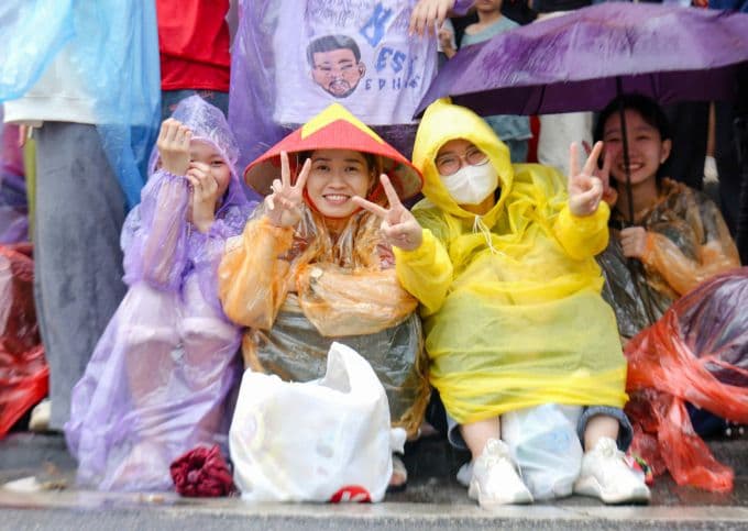 Người dân Hà Nội mặc áo mưa, đội nón lá, kiên cường chờ xem diễu binh, diễu hành trong mưa lớn giữa mùa lũ.