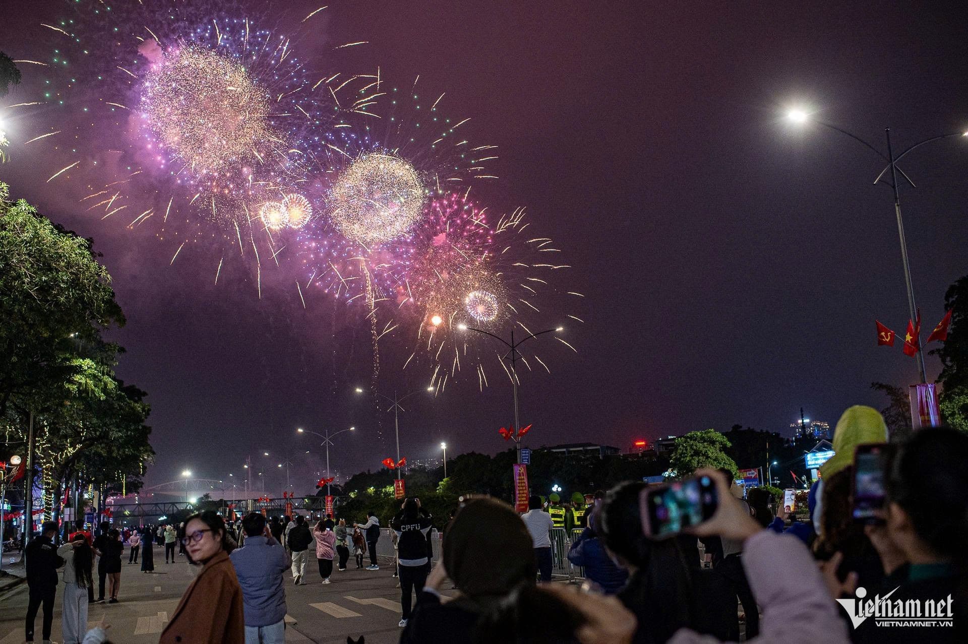Người dân Hà Nội phấn khích chiêm ngưỡng màn pháo hoa nghệ thuật từ đường phố.