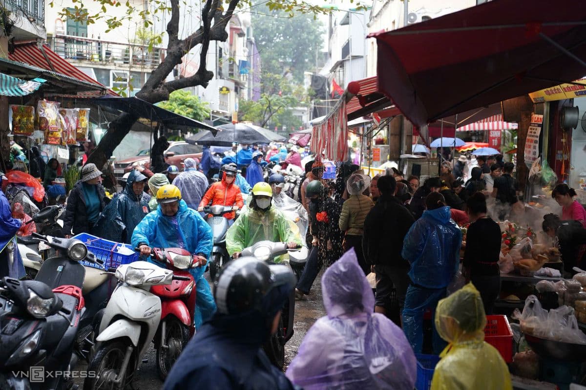 Người dân hối hả mua sắm tại chợ Tết đông đúc trong ngày mưa chuẩn bị cúng Ông Táo