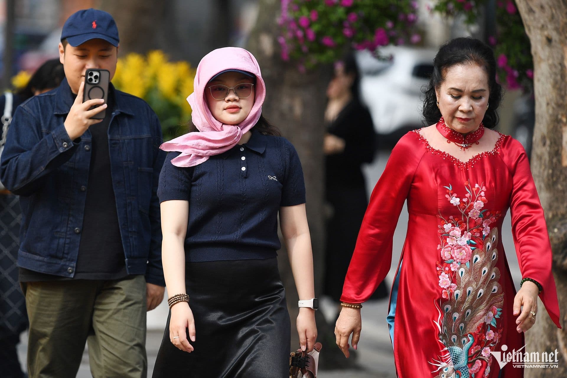 Người dân đi bộ trên phố Hà Nội vào một ngày thời tiết ôn hòa, thể hiện cuộc sống thường nhật chịu ảnh hưởng của thời tiết.