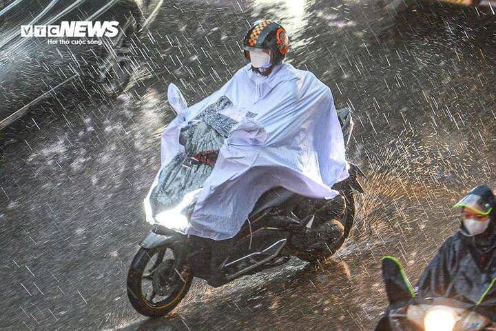 Người dân đi xe máy trong mưa phùn, biểu tượng cho thời tiết nồm ẩm đặc trưng của miền Bắc