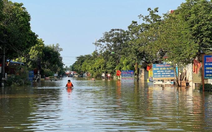 Người dân lội qua đường làng ngập sâu tại Đa Phúc trong trận lũ lịch sử