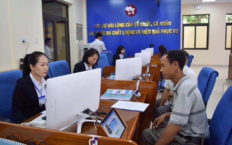 Người dân làm thủ tục hành chính tại trung tâm dịch vụ, thể hiện bối cảnh chính sách tiền lương ảnh hưởng đến người lao động.