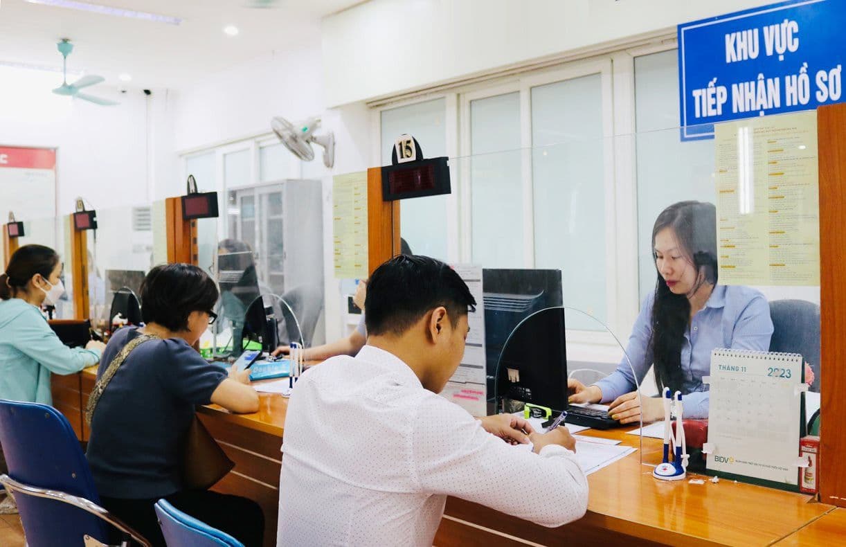 Người dân làm thủ tục tại quầy tiếp nhận hồ sơ, tượng trưng cho việc tìm kiếm hỗ trợ hoặc việc làm.
