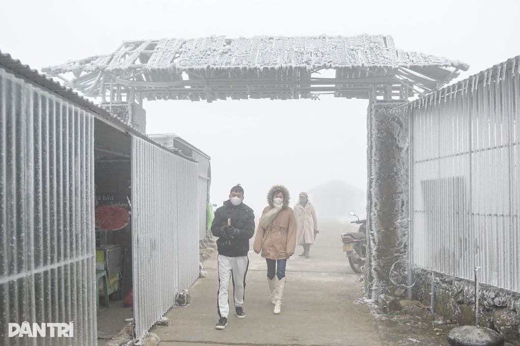 Người dân mặc áo ấm dày dặn đi lại trong sương giá tại vùng núi phía Bắc, khung cảnh phủ đầy băng tuyết.