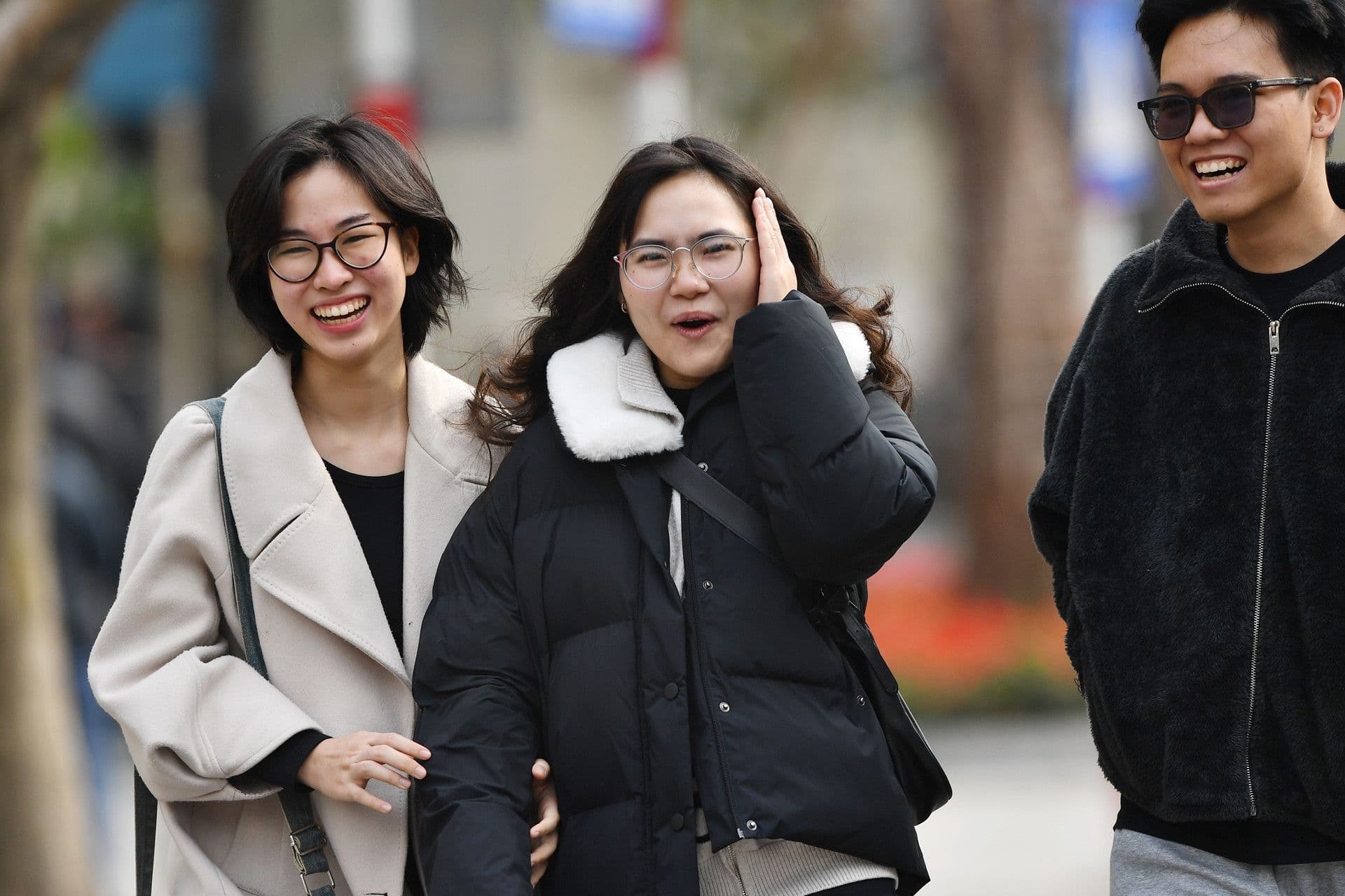 Người dân mặc áo ấm, vui vẻ đi bộ trong tiết trời se lạnh ở miền Bắc, thể hiện sự thích nghi với không khí lạnh.