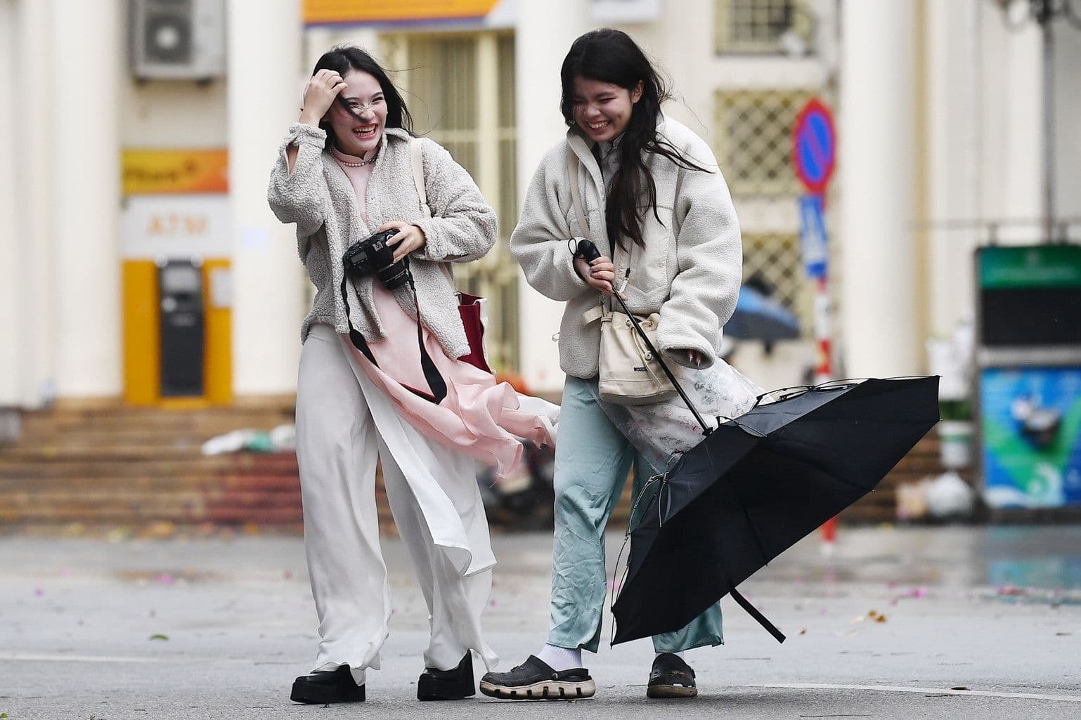 Người dân miền Bắc che ô đi trong mưa lạnh khi không khí lạnh tăng cường.