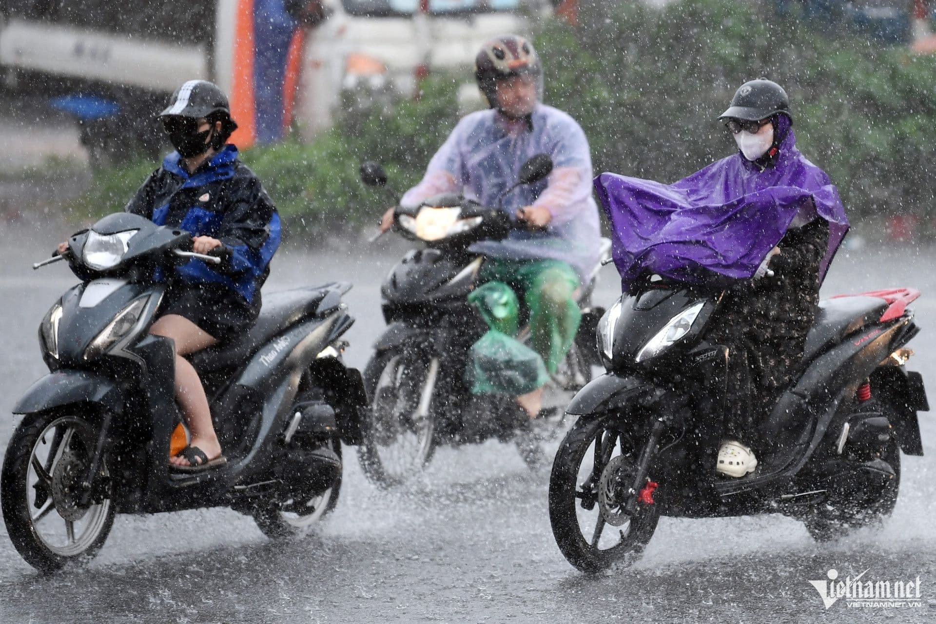 Người dân miền Bắc di chuyển trong mưa lớn do ảnh hưởng của bão Narra