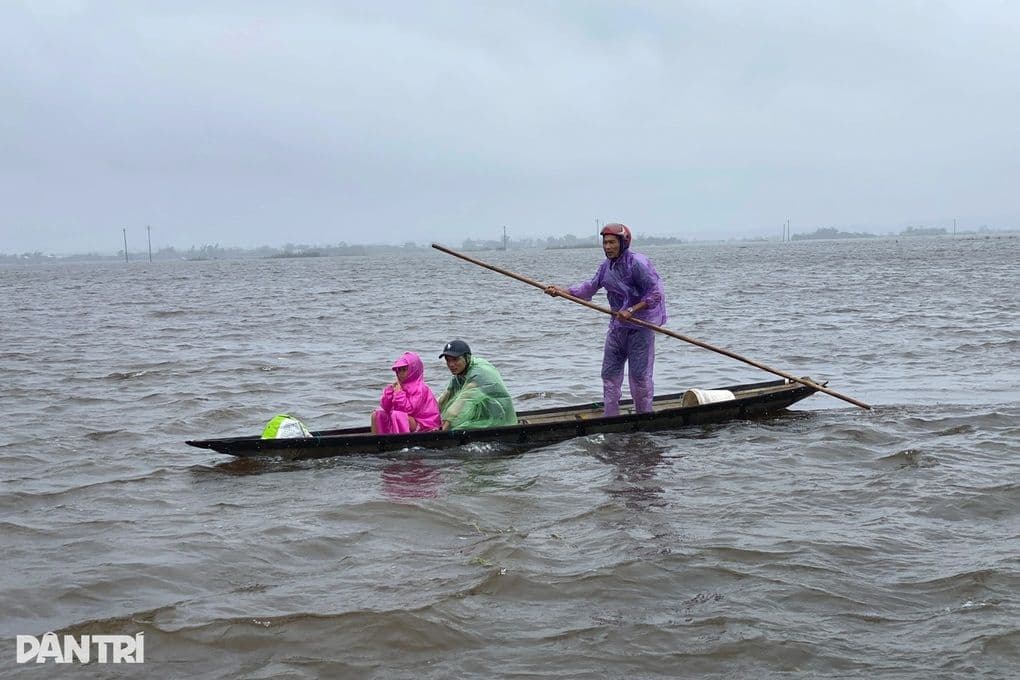 Người dân miền Trung chèo thuyền trên vùng nước lũ do mưa lớn kéo dài