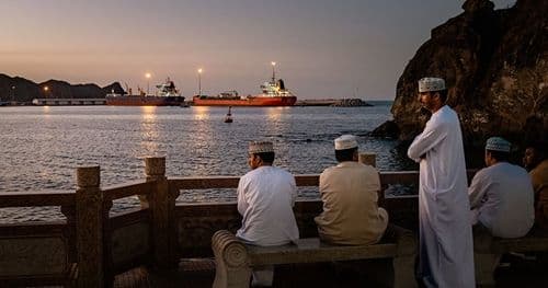 Người dân nhìn ra biển với tàu thuyền, tượng trưng cho vai trò của eo biển Hormuz trong vận chuyển dầu mỏ toàn cầu