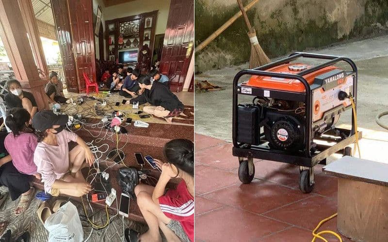 Người dân sạc điện thoại từ máy phát điện trong khu vực bị mất điện do ngập lụt.