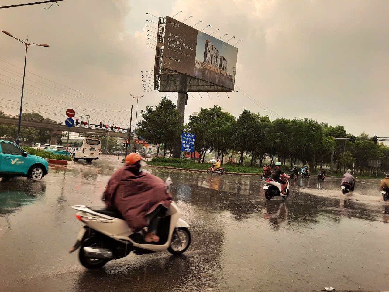 Người dân Sài Gòn di chuyển trên đường ướt sau mưa, thể hiện sự thất thường của thời tiết.