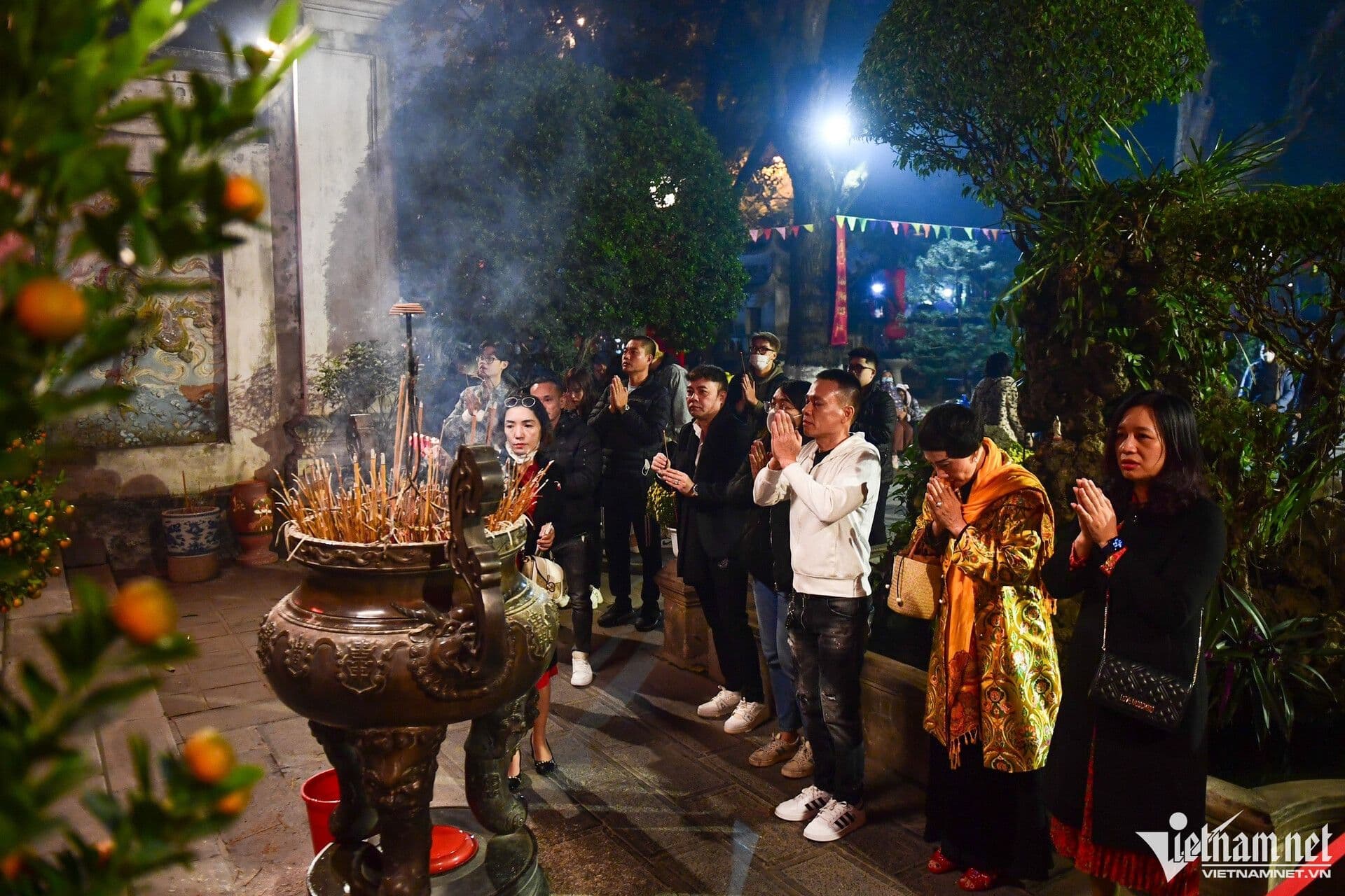 Người dân thành kính dâng hương và cầu nguyện trong đêm Rằm tháng Giêng tại một ngôi chùa.