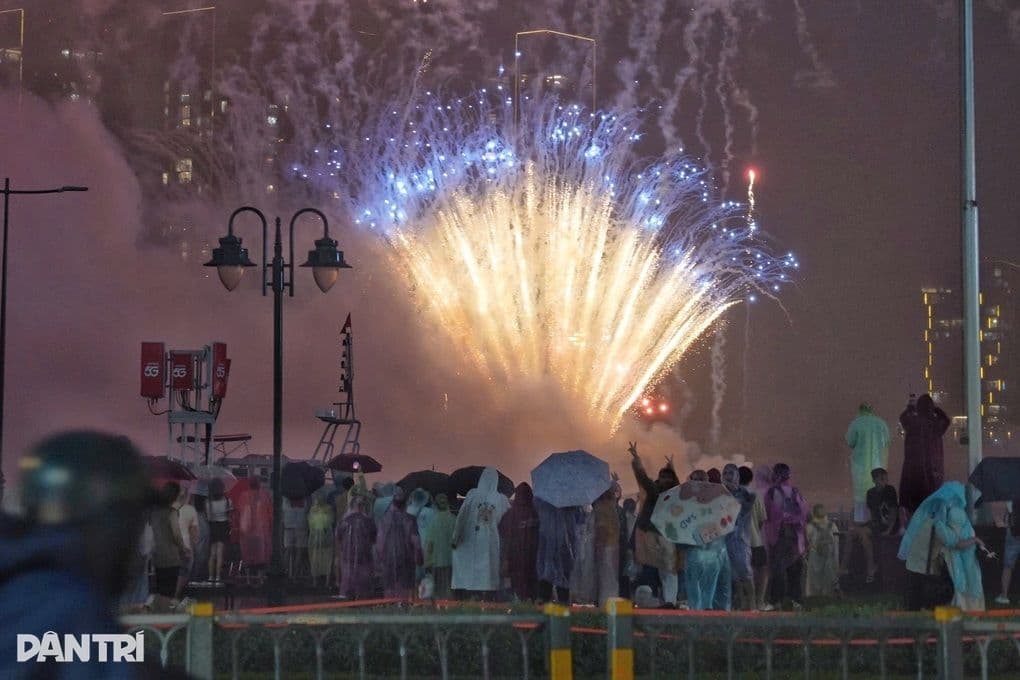 Người dân TP.HCM kiên cường đội mưa, hướng mắt về phía pháo hoa rực sáng đêm Quốc khánh.