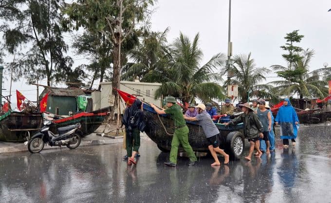 Người dân và lực lượng chức năng hỗ trợ di chuyển thuyền bè lên bờ để tránh bão Wipha.