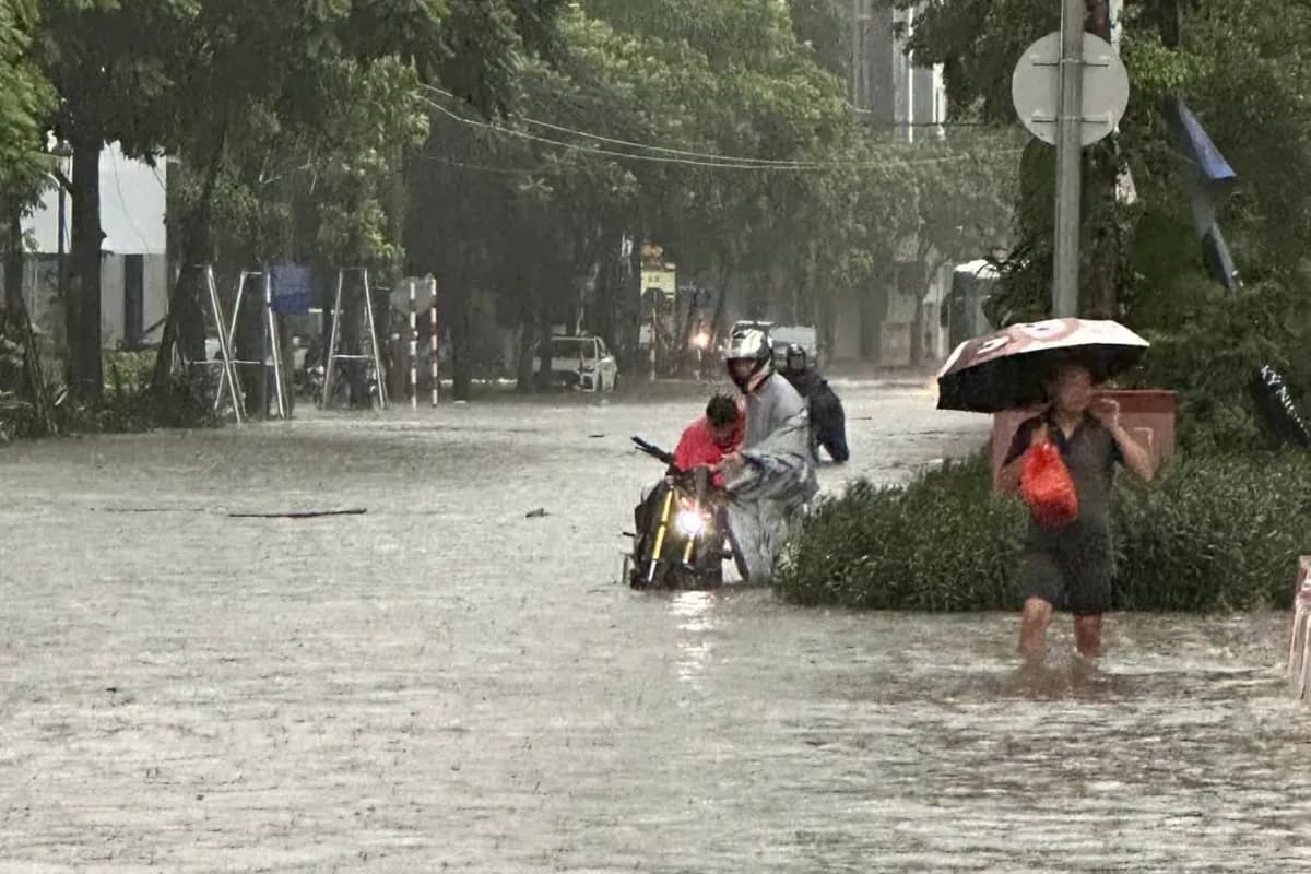 Người dân và phương tiện chật vật di chuyển trên các tuyến đường lớn ở Hà Nội bị ngập sâu gần một mét.