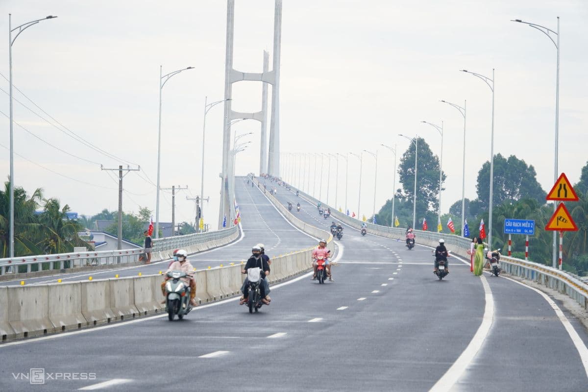 Người dân và phương tiện di chuyển trên cầu Rạch Miễu 2, thể hiện tác động tích cực của hạ tầng mới đến đời sống.