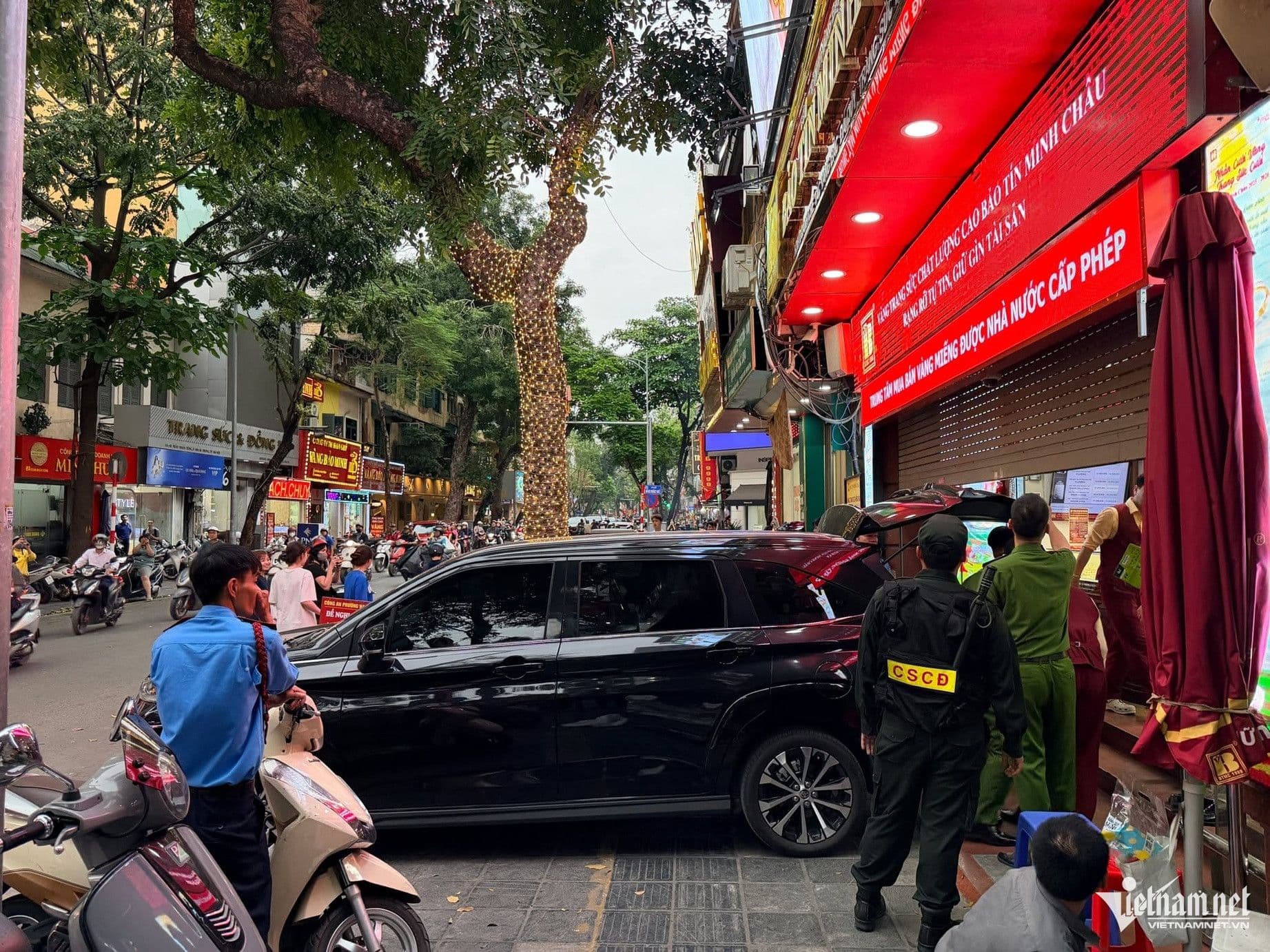 Người dân và phương tiện giao thông tập trung gần cửa hàng Bảo Tín Minh Châu đang bị công an điều tra.