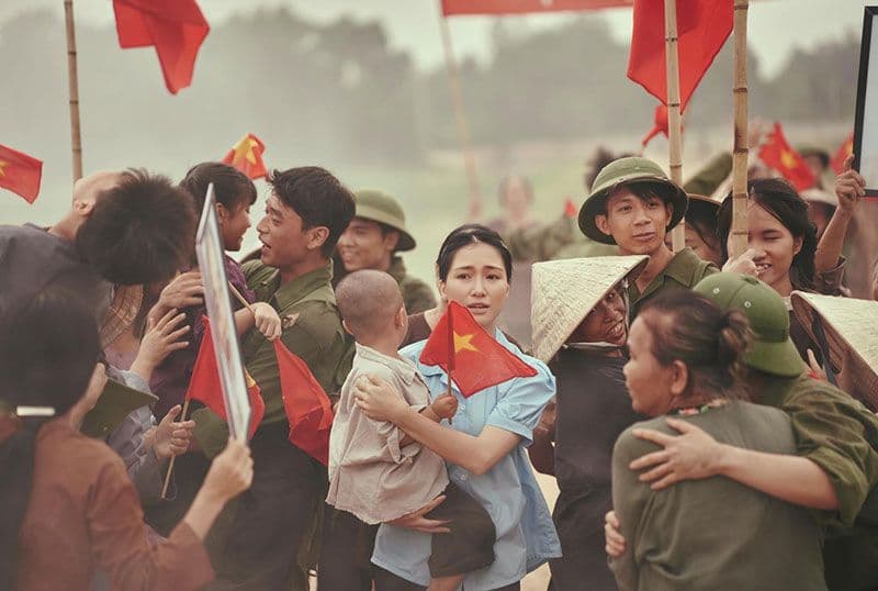 Người dân Việt Nam cầm cờ Tổ quốc, thể hiện niềm vui và tinh thần dân tộc trong ngày lễ lớn