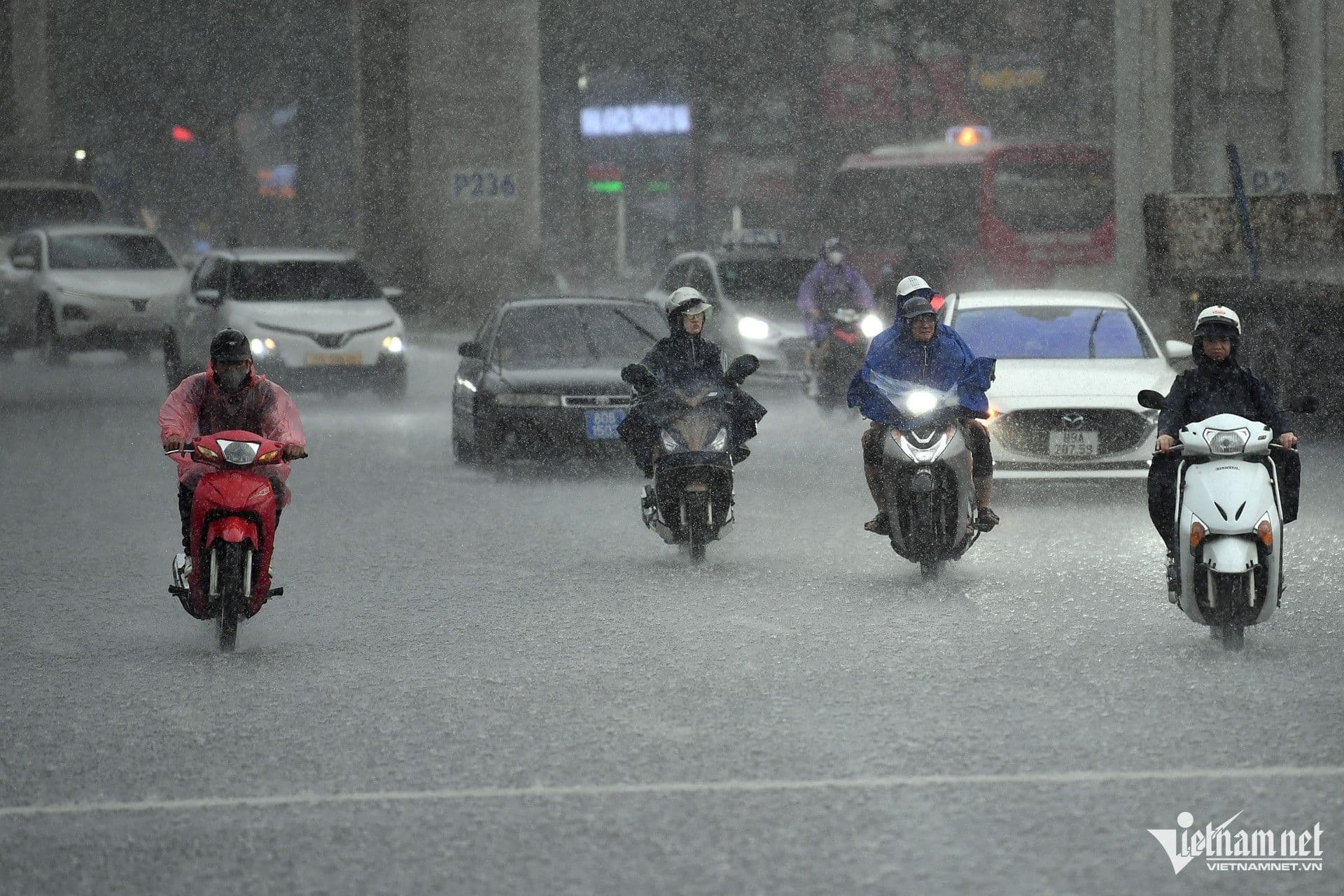 Người dân Việt Nam di chuyển trên đường phố ngập nước trong cơn mưa lớn