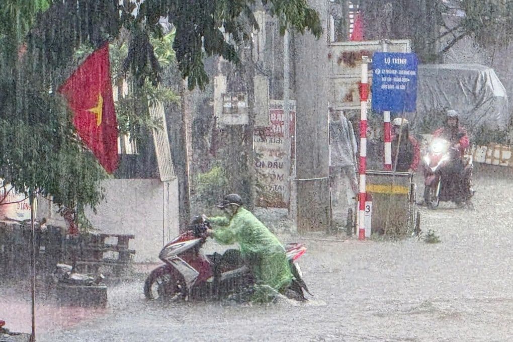 Người dân Việt Nam di chuyển trong mưa lớn và ngập lụt do ảnh hưởng của bão.