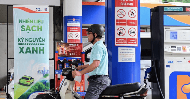 Người dân đổ xăng E10 tại trạm xăng với biểu ngữ "Nhiên liệu sạch Kỷ nguyên xanh", thể hiện xu hướng năng lượng bền vững của Việt Nam.