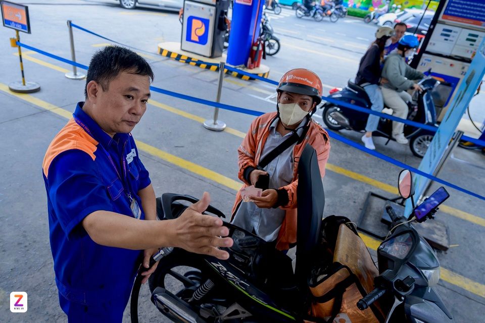 Người dân đổ xăng tại trạm xăng, phản ánh biến động giá xăng dầu và tác động lên đời sống.