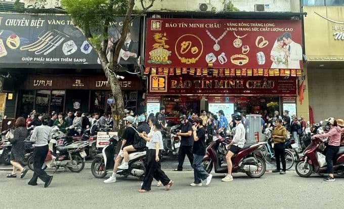 Người dân xếp hàng dài mua vàng tại cửa hàng, thể hiện cơn sốt vàng và sự quan tâm lớn của công chúng.