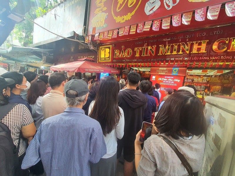 Người dân xếp hàng dài trước cửa hàng Bảo Tín Minh Châu để mua vàng trong cơn sốt giá.