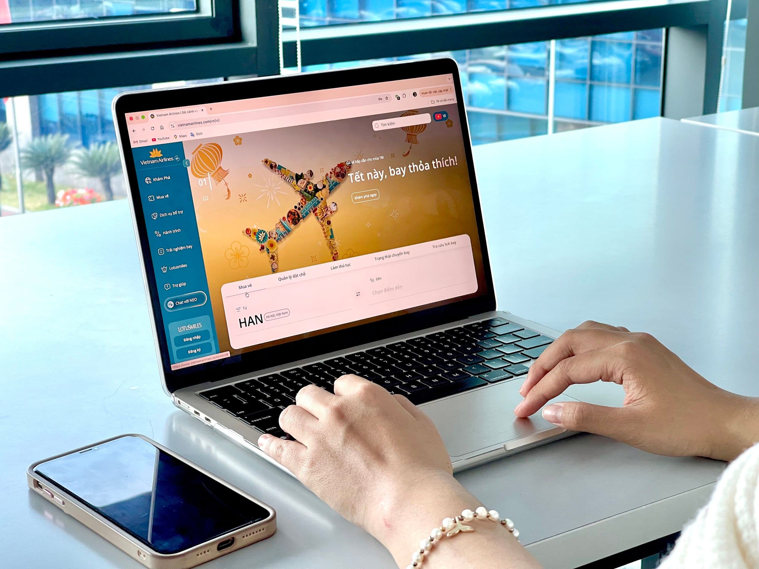 Người dùng trải nghiệm website mới của Vietnam Airlines với giao diện đặt vé hiện đại và chủ đề Tết.