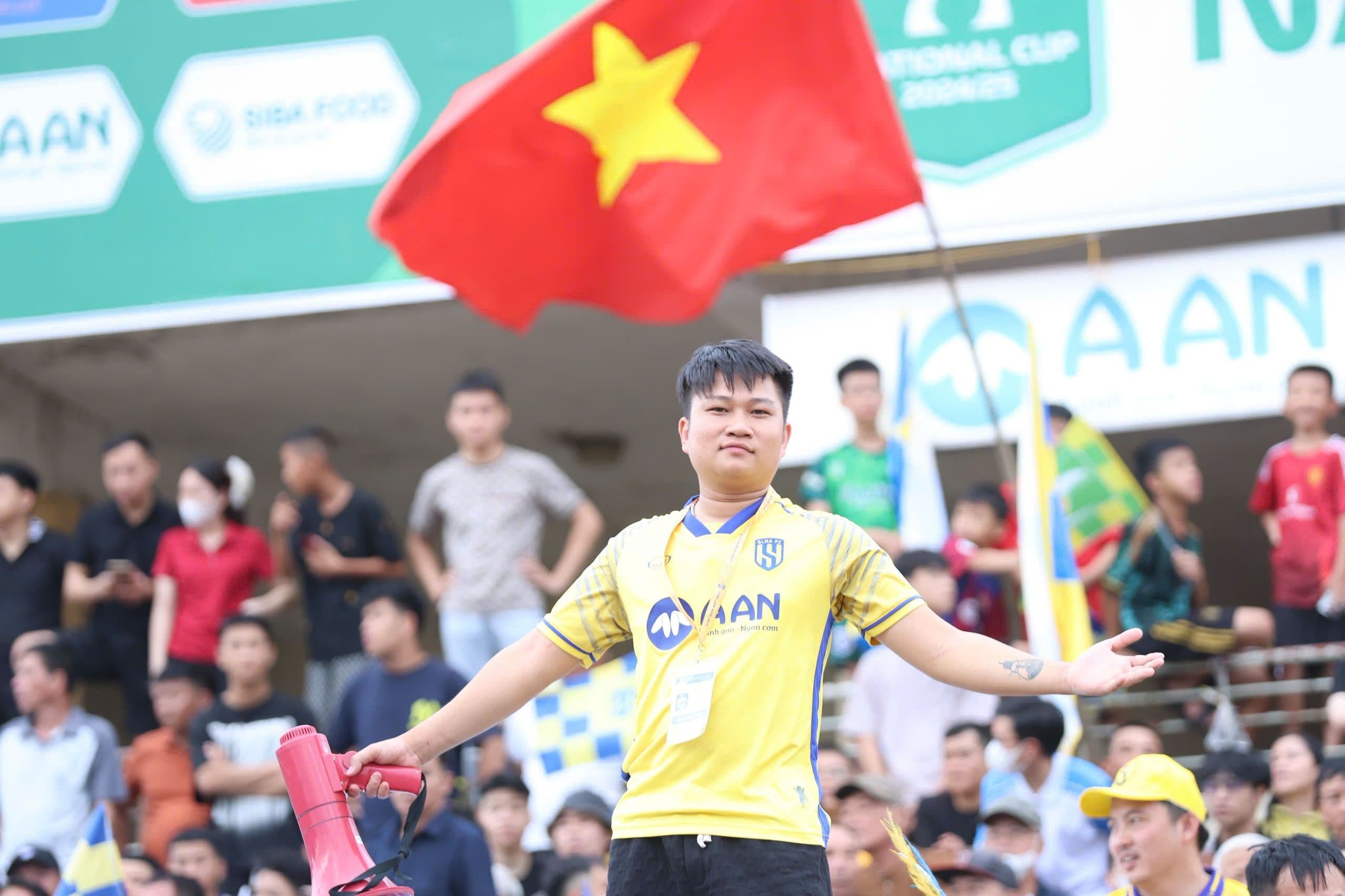 Người hâm mộ SLNA cuồng nhiệt cổ vũ với cờ và loa tại sân Vinh.