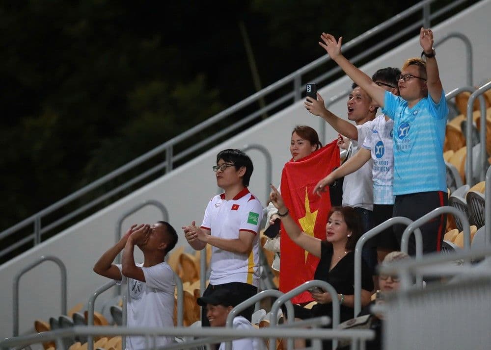 Người hâm mộ Thép Xanh Nam Định cổ vũ với cờ Việt Nam, thể hiện niềm hy vọng vào sự phát triển của bóng đá nước nhà.