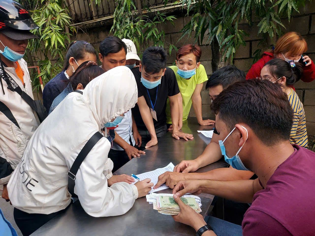 Người lao động nhận lương tiền mặt, minh họa quy định mới về thanh toán lương trên 5 triệu đồng.