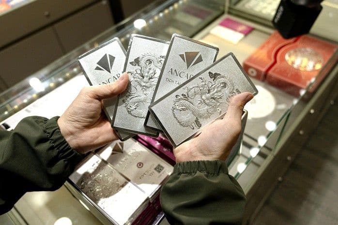 Người mua đang cầm những thỏi bạc Ancarat, thể hiện sự biến động của thị trường bạc