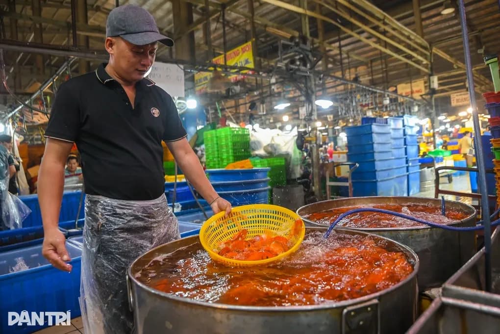 Người đàn ông đang múc cá chép vàng để cúng ông Công ông Táo, nghi lễ quan trọng trước khi bao sái bàn thờ.