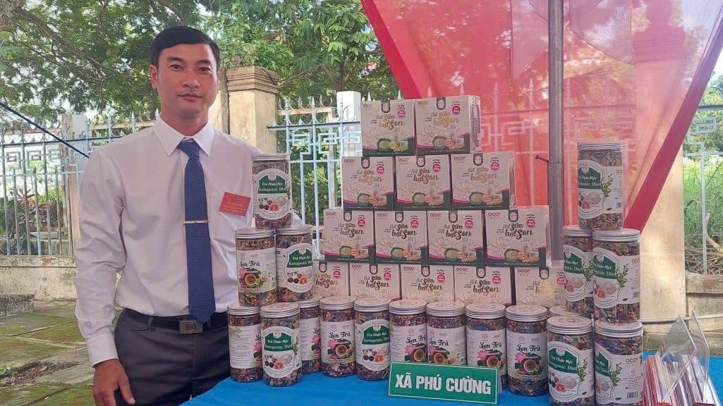 Người đàn ông giới thiệu các sản phẩm nông nghiệp đã được đóng gói và xây dựng thương hiệu, thể hiện sự đổi mới và khát vọng nâng tầm giá trị Việt của thế hệ trẻ.