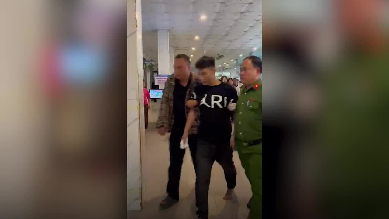 Người đàn ông gây rối bị lực lượng chức năng áp giải sau vụ tấn công tại Bệnh viện Sản Nhi Nghệ An.