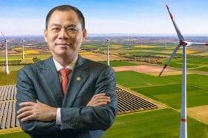 Người đàn ông đứng trước cánh đồng điện gió và tấm pin năng lượng mặt trời, tượng trưng cho nền kinh tế xanh và thông minh.