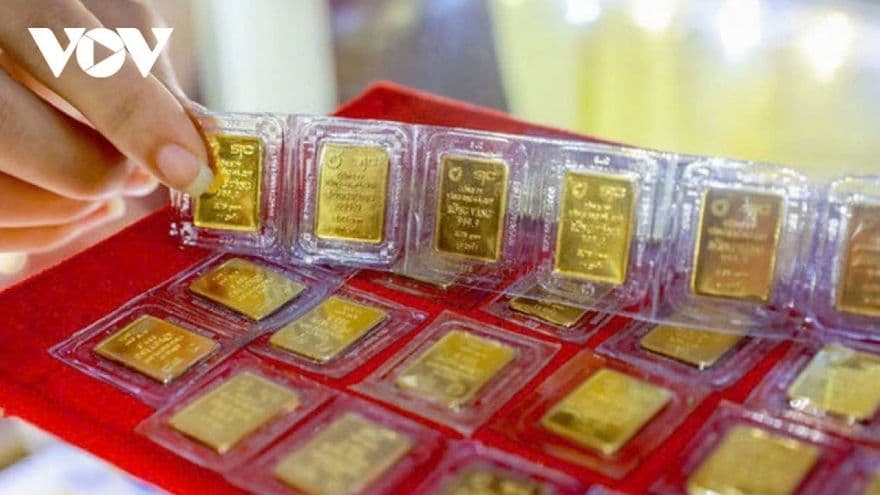 Người phụ nữ đang sắp xếp các miếng vàng SJC, liên quan đến việc Ngân hàng Nhà nước xem xét cấp phép sản xuất vàng miếng