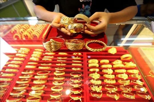Người phụ nữ cầm trang sức vàng, thể hiện tâm lý tránh rủi ro và ảnh hưởng của chính sách đến hành vi kinh tế.