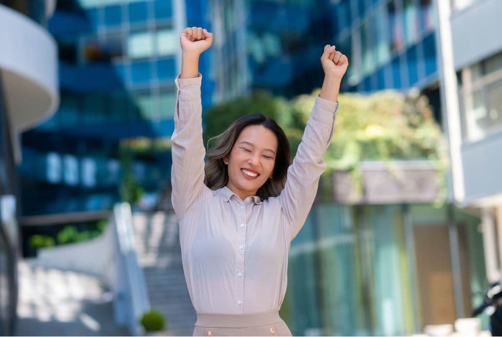 Người phụ nữ giơ tay ăn mừng thành công, thể hiện ý chí và lựa chọn cá nhân trong việc định hình vận mệnh.